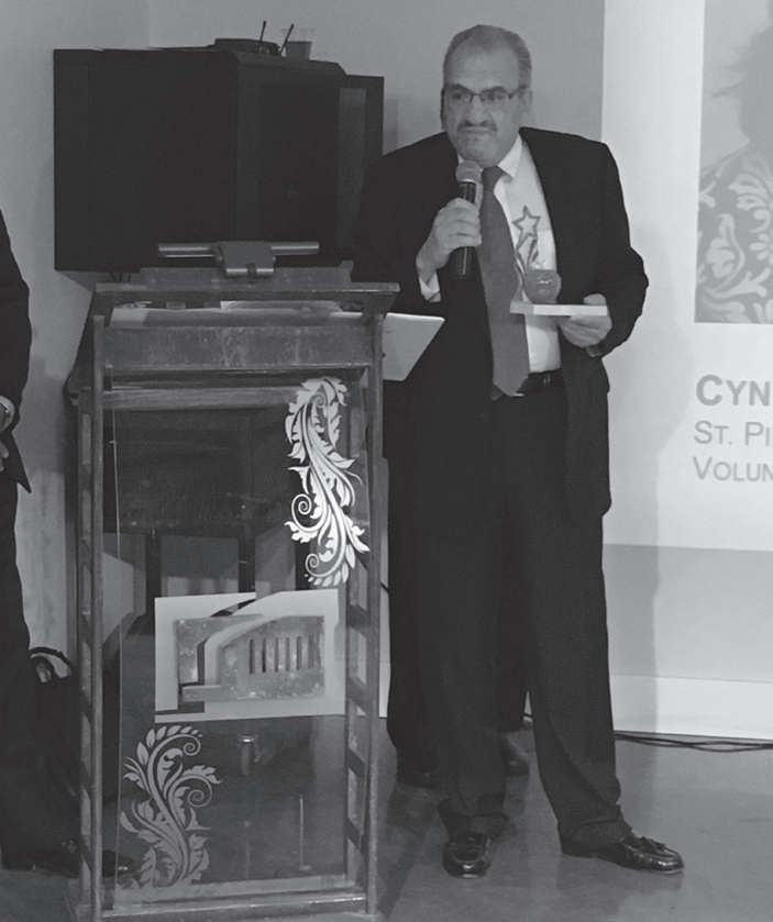 George Yapor holding his award while speaking at the podium