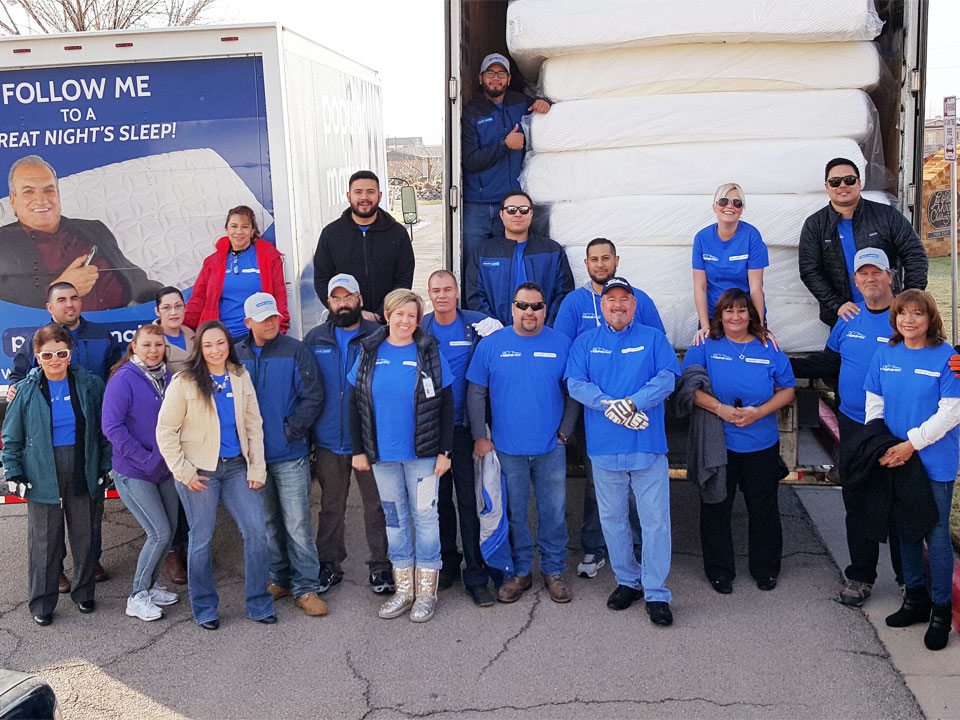 Popular Mattress donation team beside trucks loaded with mattresses